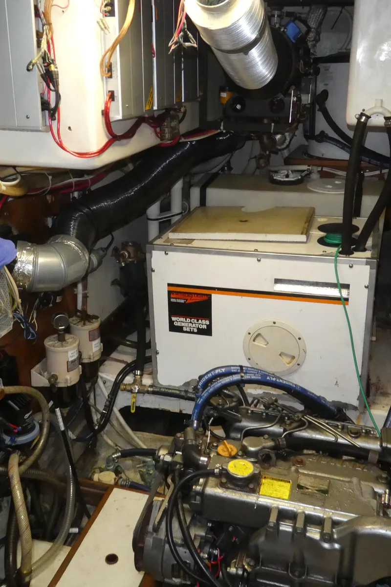 Slide: The Image of Engine room of 1990 Celestial 48 Center Cockpit sailboat, featuring mechanical components and wiring. - 34