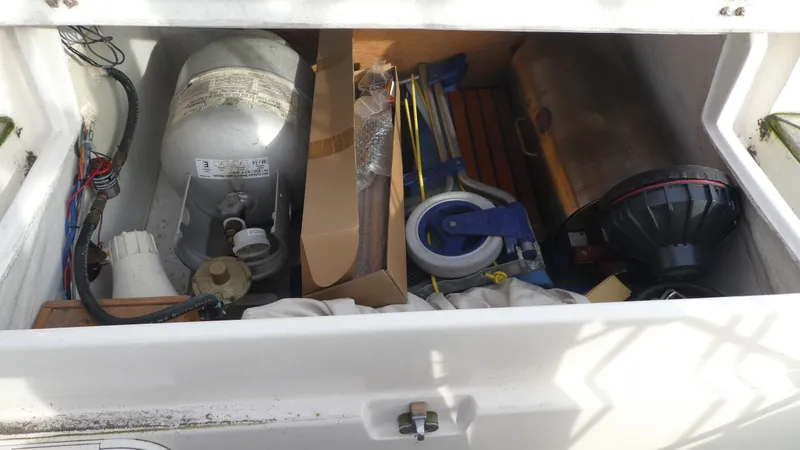 Slide: The Image of Storage compartment of 1990 Celestial 48 Center Cockpit with various equipment and supplies. - 38