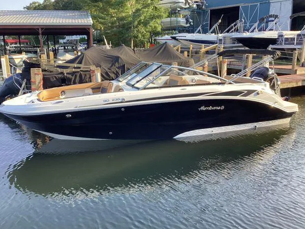 Slide: The Image of 2024 Hurricane SD235-OB boat docked by the lake, featuring sleek design and powerful outboard motor. - 1
