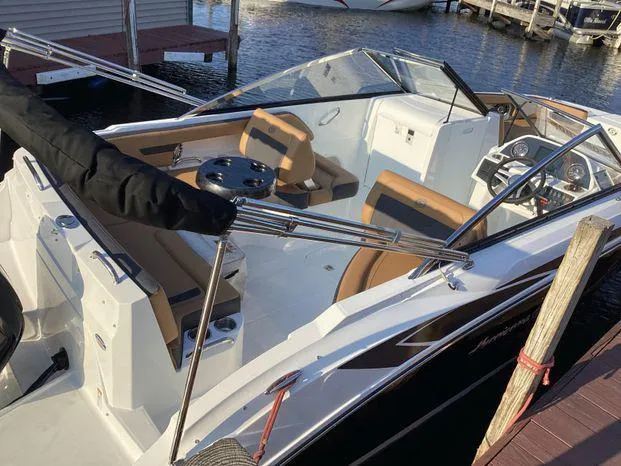 Slide: The Image of 2024 Hurricane SD235-OB boat with spacious seating and modern dashboard, docked by the water. - 10