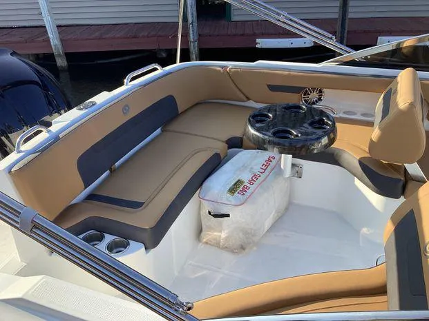 Slide: The Image of 2024 Hurricane SD235-OB boat interior with tan seating and a round table. - 5