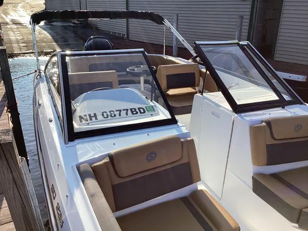 Slide: The Image of 2024 Hurricane SD235-OB boat docked, featuring tan and white seating. - 8