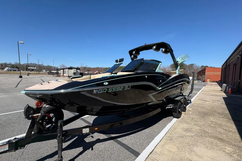 The Image of 2022 MB B52 Alpha boat on trailer in parking lot under clear blue sky. - 0
