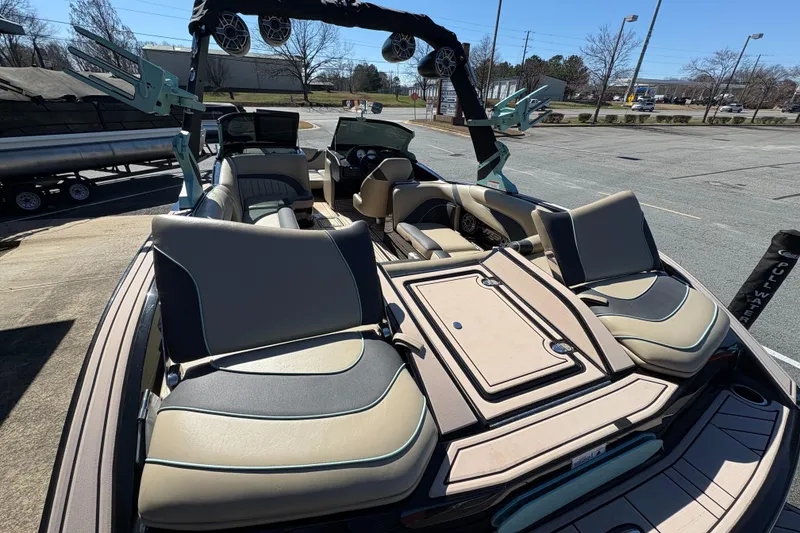 Slide: The Image of 2022 MB B52 Alpha boat interior with beige and black seating, docked outdoors. - 10