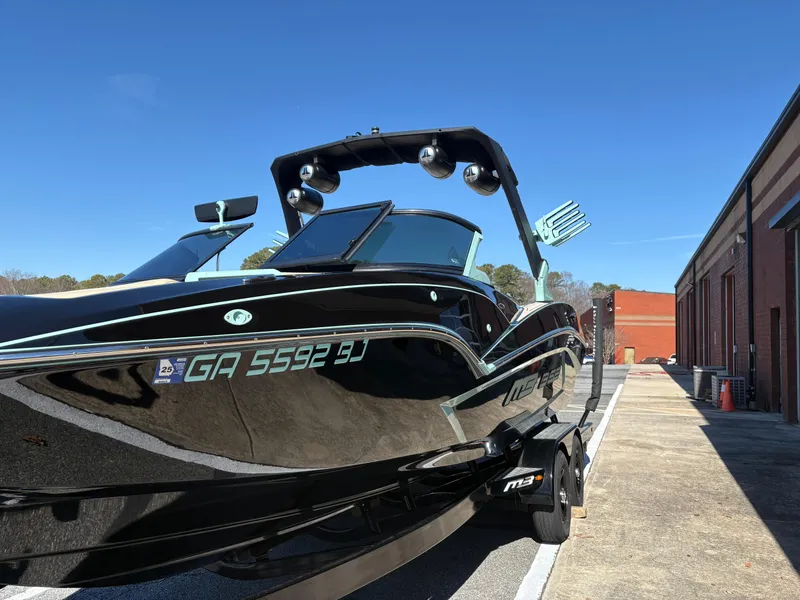 Slide: The Image of 2022 MB B52 Alpha boat on trailer, sleek black design, parked outdoors. - 2