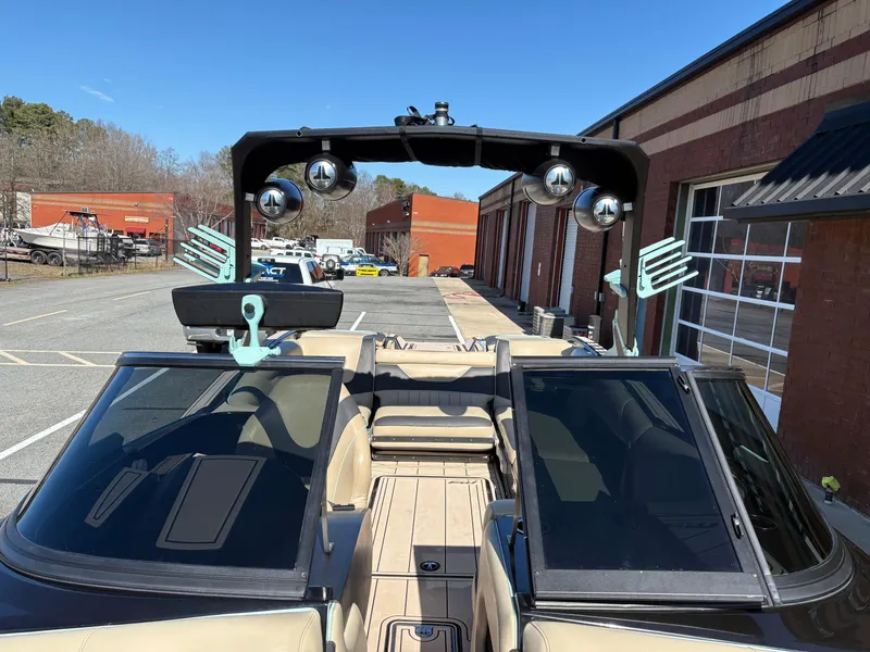 Slide: The Image of 2022 MB B52 Alpha boat with speakers and wakeboard racks, parked near industrial buildings. - 5