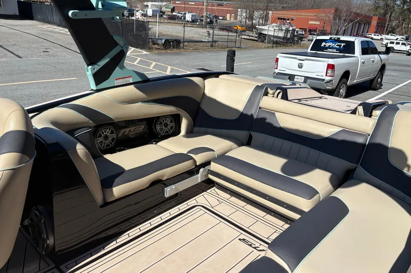 Slide: The Image of 2022 MB B52 Alpha boat interior with beige and black seating, parked in an industrial area. - 9