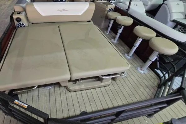 Slide: The Image of SunChaser Eclipse 23 SBX DH 2025 boat interior with beige seating and stools. - 2