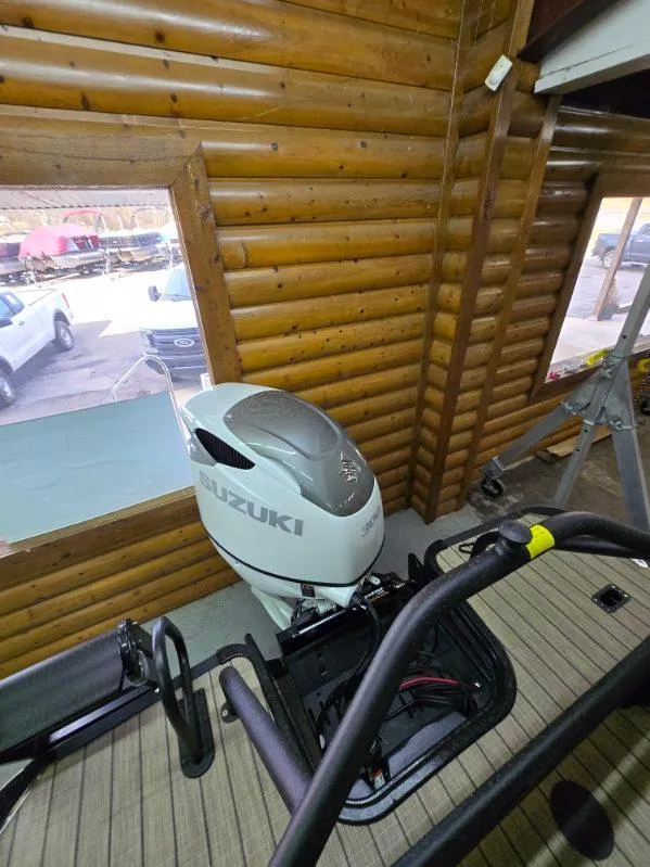Slide: The Image of 2025 SunChaser Eclipse 23 SBX DH with Suzuki outboard motor in wooden interior setting. - 8