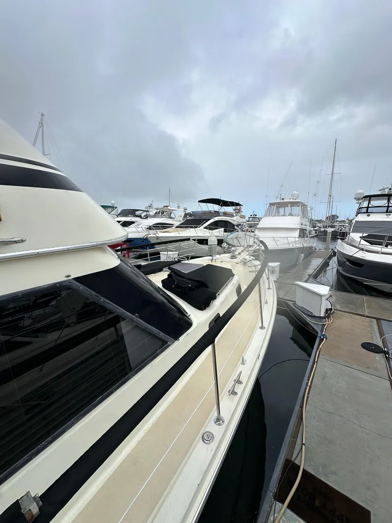 Slide: The Image of 1985 Gulfstar 49 Motor Yacht docked among other boats on a cloudy day. - 16