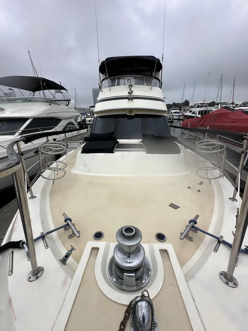 Slide: The Image of 1985 Gulfstar 49 Motor Yacht docked, showcasing spacious deck and sleek design. - 20