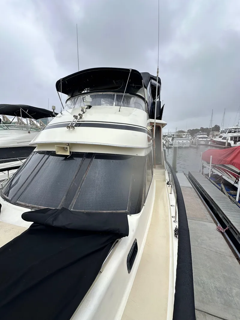 Slide: The Image of 1985 Gulfstar 49 Motor Yacht docked at a marina under cloudy skies. - 21