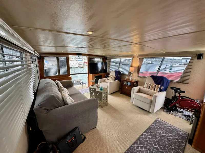 Slide: The Image of Interior of 1985 Gulfstar 49 Motor Yacht, featuring cozy seating and large windows. - 25