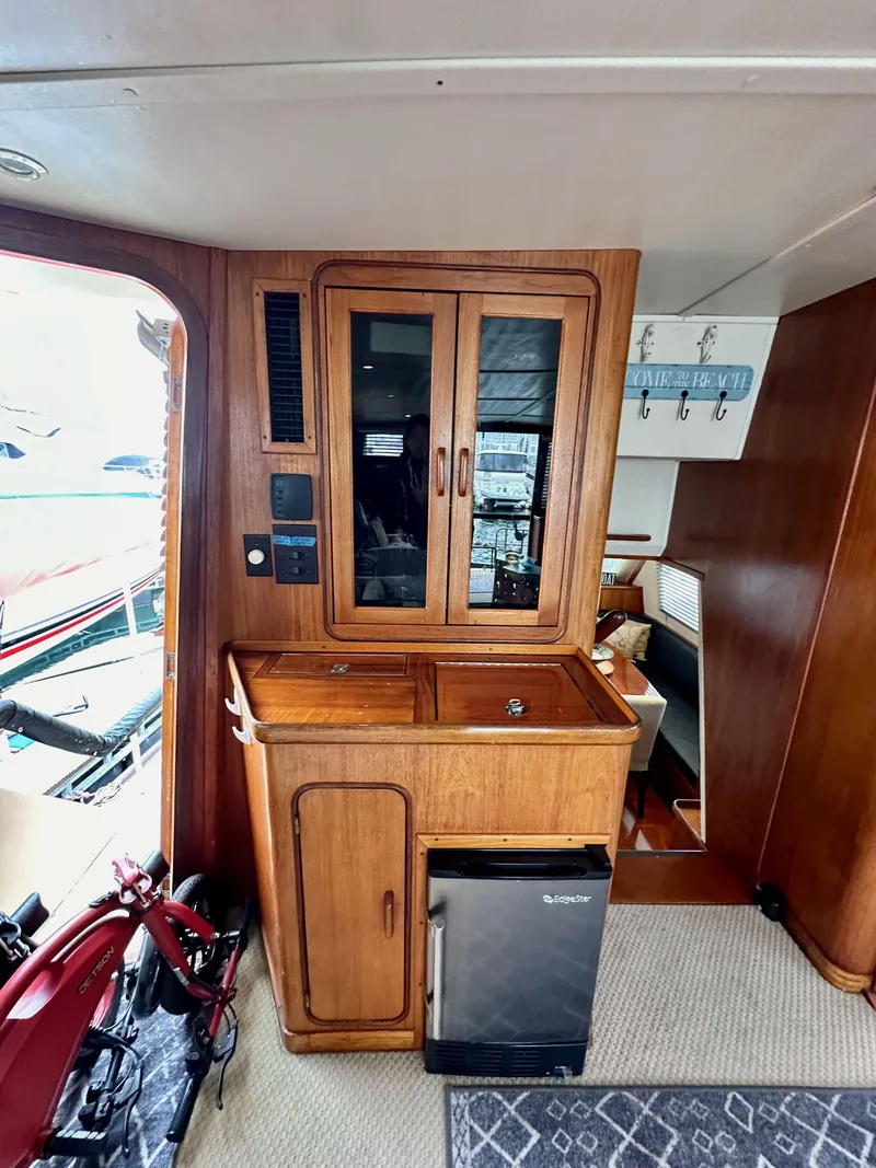Slide: The Image of 1985 Gulfstar 49 Motor Yacht interior with wooden cabinetry and mini fridge. - 37