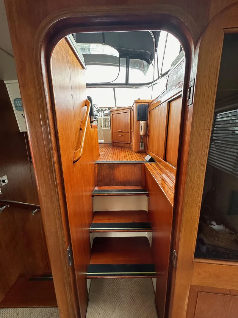 Slide: The Image of Interior view of 1985 Gulfstar 49 Motor Yacht with wooden stairs and helm. - 39