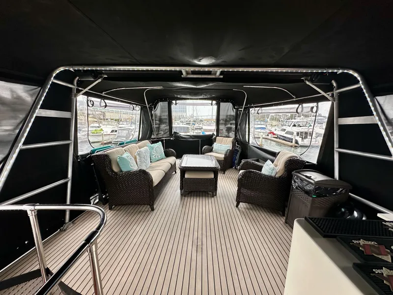 Slide: The Image of 1985 Gulfstar 49 Motor Yacht interior with wicker seating and panoramic marina views. - 45
