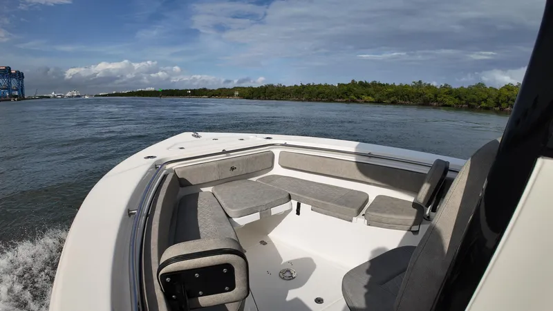 Slide: The Image of 2023 Sea Pro 239 Deluxe CC boat on water, featuring spacious seating and scenic view. - 17