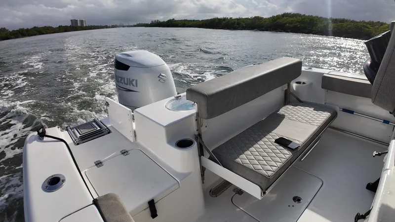 Slide: The Image of 2023 Sea Pro 239 Deluxe CC boat interior with Suzuki engine on a scenic waterway. - 19