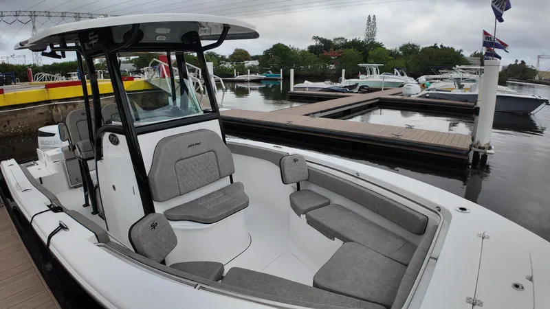Slide: The Image of 2023 Sea Pro 239 Deluxe CC boat docked, featuring spacious seating and modern design. - 21