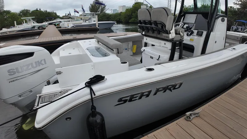 Slide: The Image of 2023 Sea Pro 239 Deluxe CC boat docked, featuring Suzuki outboard engine. - 24