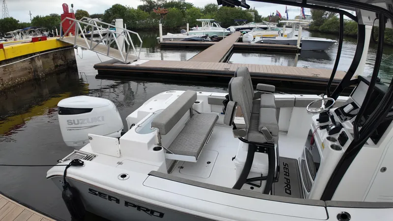 Slide: The Image of 2023 Sea Pro 239 Deluxe CC boat docked, featuring a Suzuki outboard motor. - 25