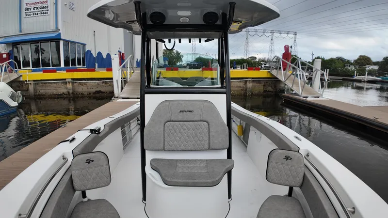 Slide: The Image of 2023 Sea Pro 239 Deluxe CC boat docked, featuring spacious seating and modern design. - 29