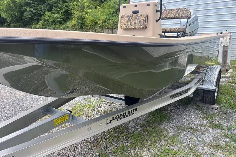 Slide: The Image of 2025 Carolina Skiff E18 JVX CC boat on trailer, parked outdoors. - 1