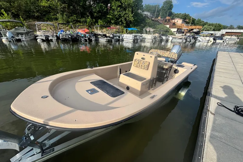 Slide: The Image of 2025 Carolina Skiff E18 JVX CC boat docked on a calm lake. - 10