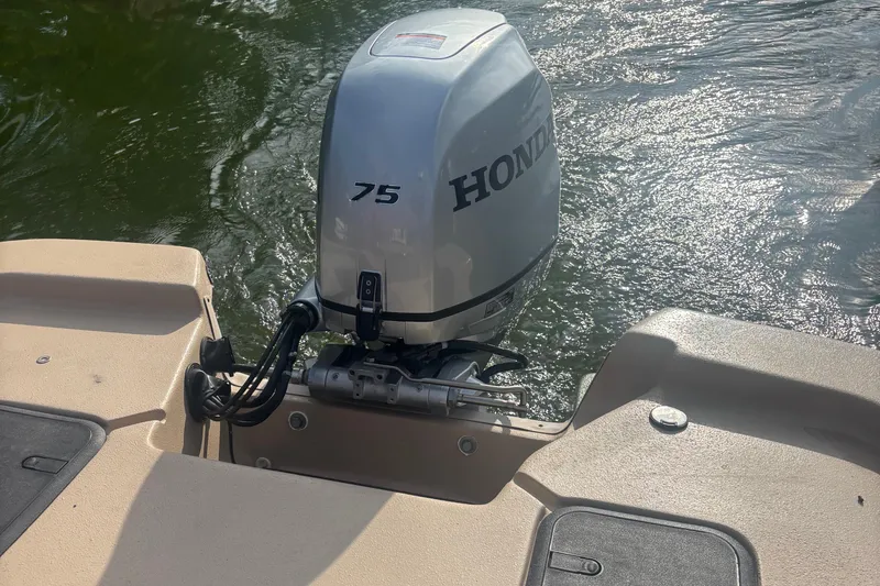 Slide: The Image of 2025 Carolina Skiff E18 JVX CC with Honda 75 outboard motor on water. - 14