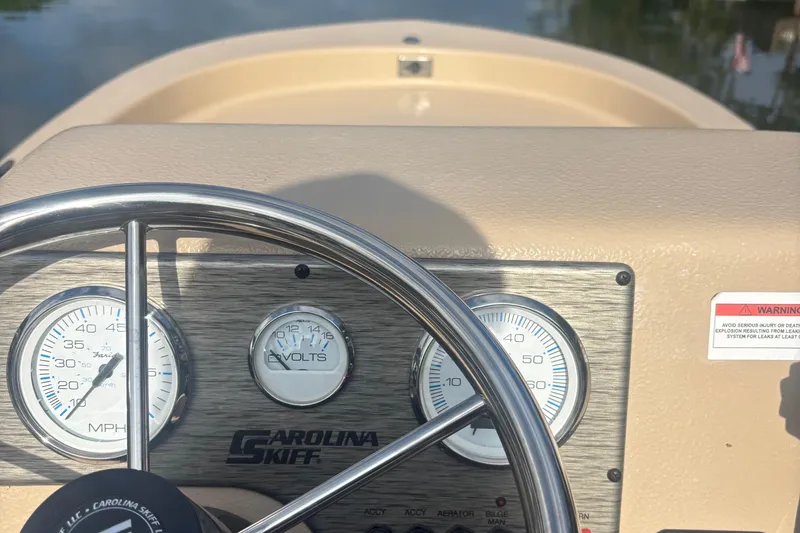 Slide: The Image of 2025 Carolina Skiff E18 JVX CC dashboard with steering wheel and gauges. - 15