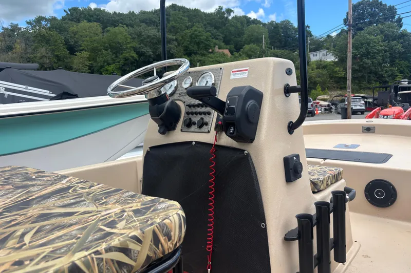 Slide: The Image of 2025 Carolina Skiff E18 JVX CC boat console with camo seats and steering wheel. - 2