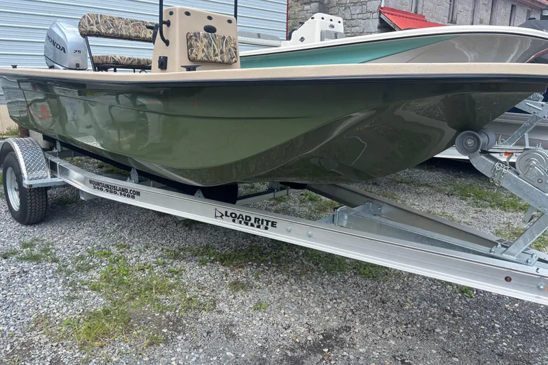 Slide: The Image of 2025 Carolina Skiff E18 JVX CC boat on Load Rite trailer, green hull, camo seats. - 4