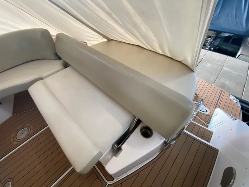 Slide: The Image of 2012 Regal 42 Sport Coupe interior seating with beige upholstery and wooden deck. - 12