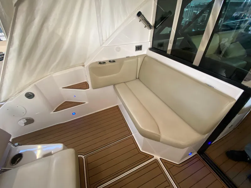 Slide: The Image of Interior seating area of a 2012 Regal 42 Sport Coupe with beige cushions and wood flooring. - 14