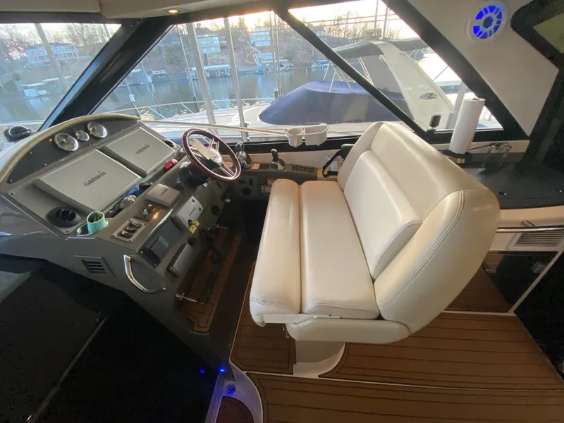 Slide: The Image of 2012 Regal 42 Sport Coupe helm with white seating and modern dashboard controls. - 19