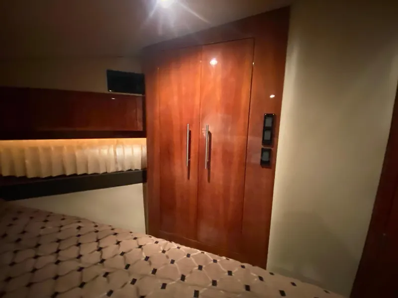 Slide: The Image of Open refrigerator inside 2012 Regal 42 Sport Coupe yacht, featuring wooden cabinetry and striped carpet. - 40