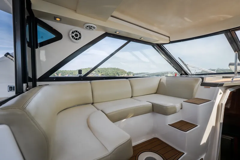 Slide: The Image of Interior of 2012 Regal 42 Sport Coupe yacht with beige seating and panoramic windows. - 25