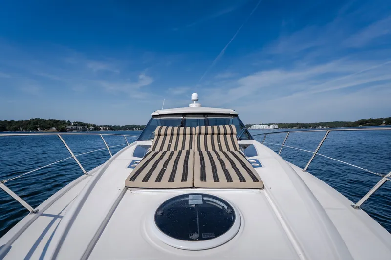 Slide: The Image of 2012 Regal 42 Sport Coupe yacht with striped sunbed on deck, cruising on a sunny day. - 42