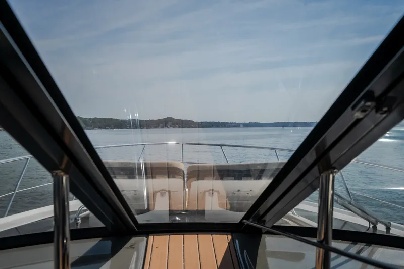 Slide: The Image of 2012 Regal 42 Sport Coupe yacht cruising on calm waters under a clear sky. - 34