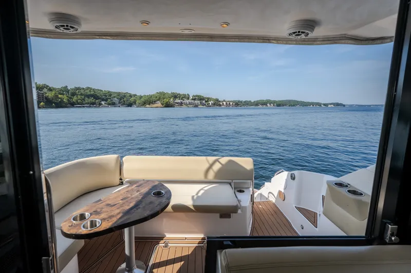Slide: The Image of 2012 Regal 42 Sport Coupe yacht with scenic lake view from deck seating area. - 67