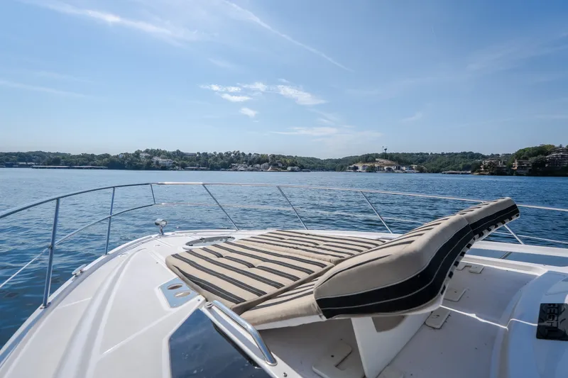 Slide: The Image of 2012 Regal 42 Sport Coupe yacht on serene water with scenic shoreline view. - 39