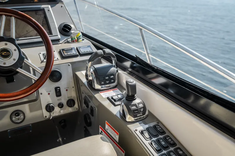 Slide: The Image of 2012 Regal 42 Sport Coupe helm with controls and steering wheel, overlooking the ocean. - 31
