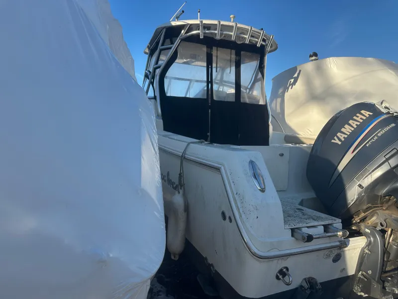 Slide: The Image of 2007 Sailfish 30-06 Express boat with Yamaha outboard motor, docked and covered. - 11