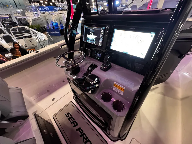 Slide: The Image of 2025 Sea Pro 292 DLX boat dashboard with modern navigation displays at a boat show. - 19