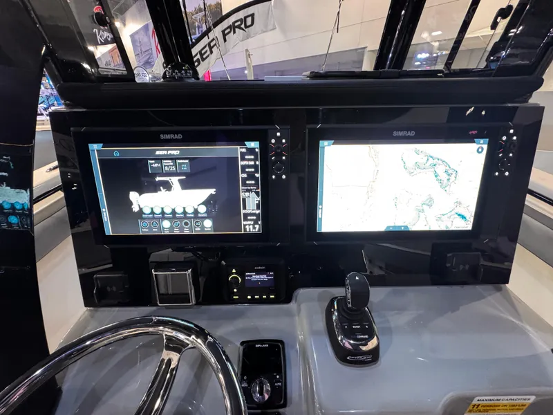 Slide: The Image of 2025 Sea Pro 292 DLX dashboard with dual Simrad displays and navigation controls. - 21