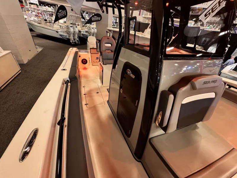 Slide: The Image of 2025 Sea Pro 292 DLX boat interior at a boat show, showcasing seating and console design. - 26