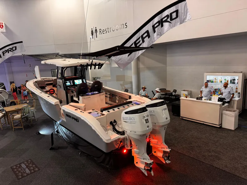 Slide: The Image of 2025 Sea Pro 292 DLX boat displayed indoors with dual Suzuki engines. - 4
