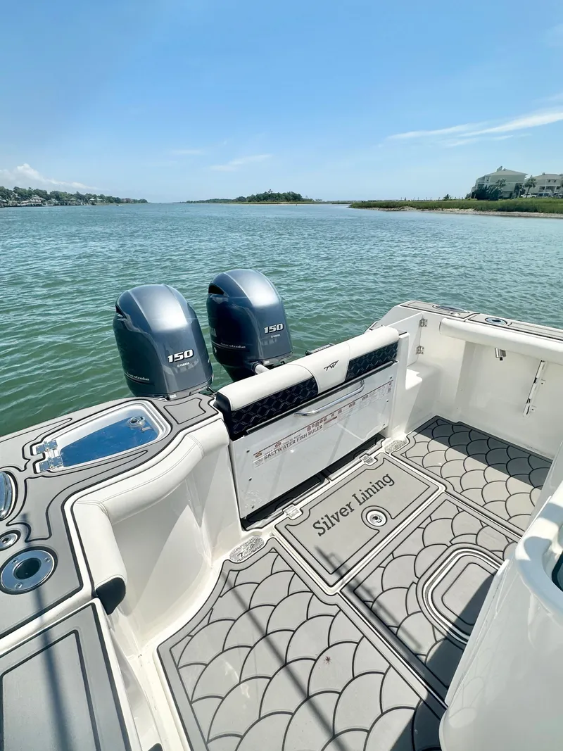 Slide: The Image of 2021 Tidewater 256 CC Adventure boat with dual engines on a scenic waterway. - 11