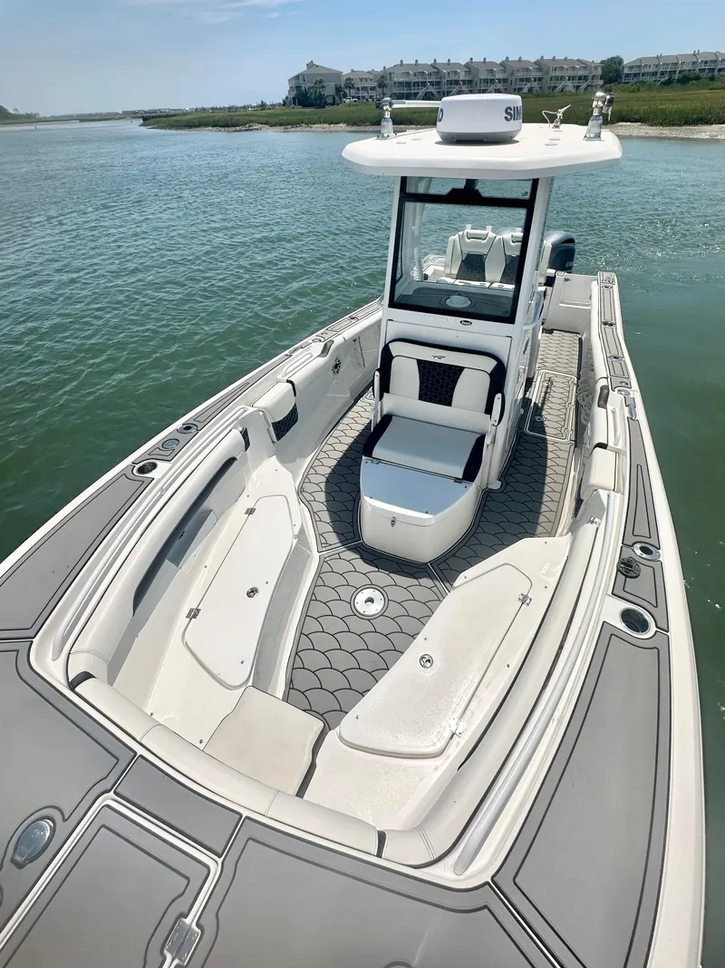 Slide: The Image of 2021 Tidewater 256 CC Adventure boat on calm water, featuring spacious seating and modern design. - 8