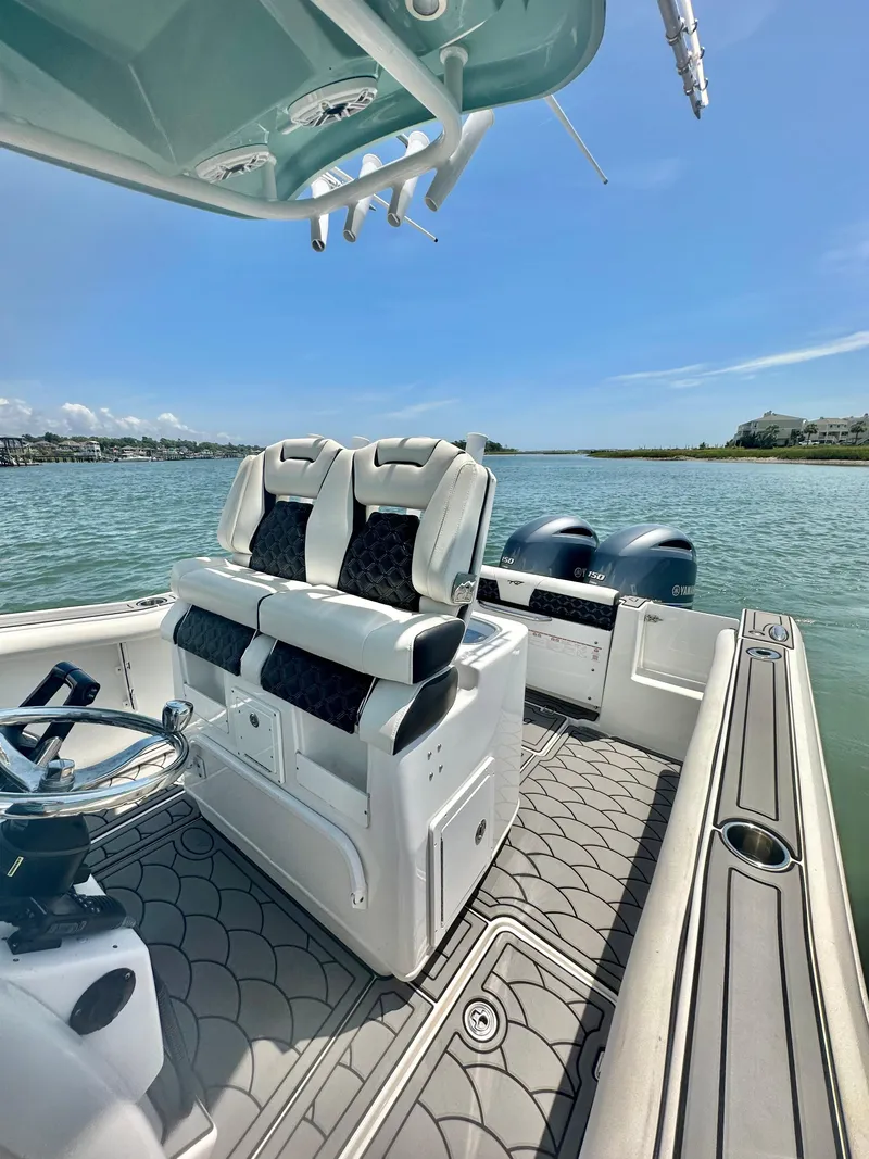 Slide: The Image of 2021 Tidewater 256 CC Adventure boat interior with dual seats and scenic water view. - 9